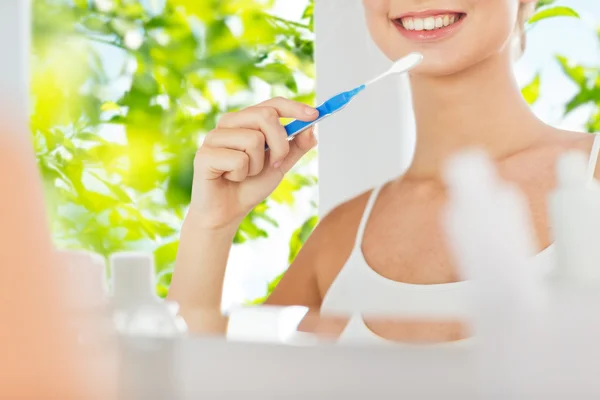 Mulher com escova de dentes limpeza dentes no banheiro — Fotografia de Stock