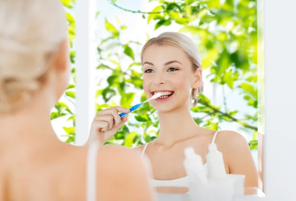 Frau mit Zahnbürste putzt Zähne im Bad — Stockfoto