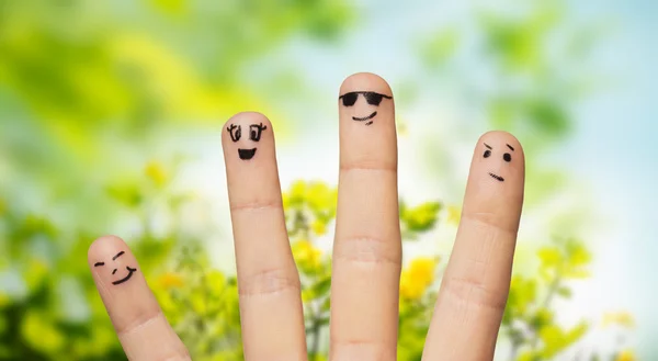 Gros plan des doigts avec des visages souriants sur la nature — Photo