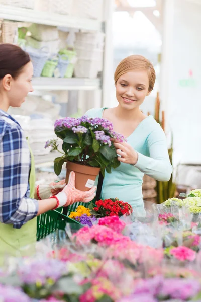 Glückliche Frauen wählen Blumen im Gewächshaus oder im Geschäft — Stockfoto