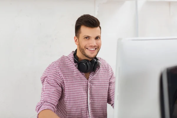 Creatieve man met hoofdtelefoon en computer — Stockfoto