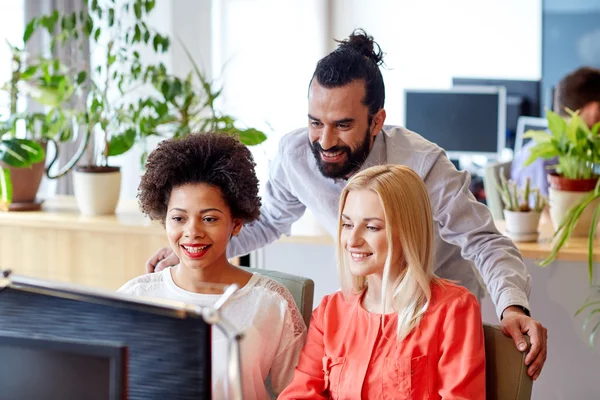 Equipe criativa feliz com computador no escritório — Fotografia de Stock