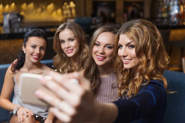 Kvinnor med smartphone med selfie på nattklubb — Stockfoto