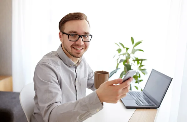 Hombre de negocios feliz con teléfono inteligente y café — Foto de Stock
