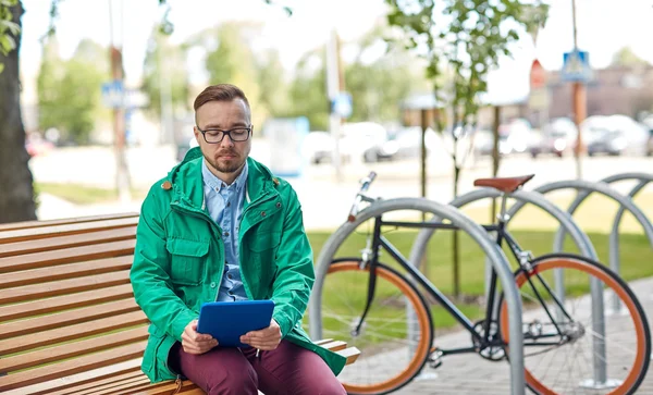 Triste joven hipster hombre con tablet PC y bicicleta — Foto de Stock