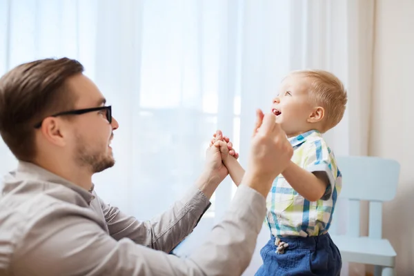 Isä pojan kanssa leikkii ja pitää hauskaa kotona — kuvapankkivalokuva