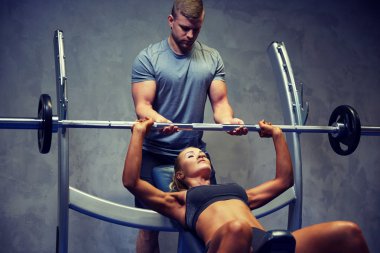 man and woman with barbell flexing muscles in gym clipart