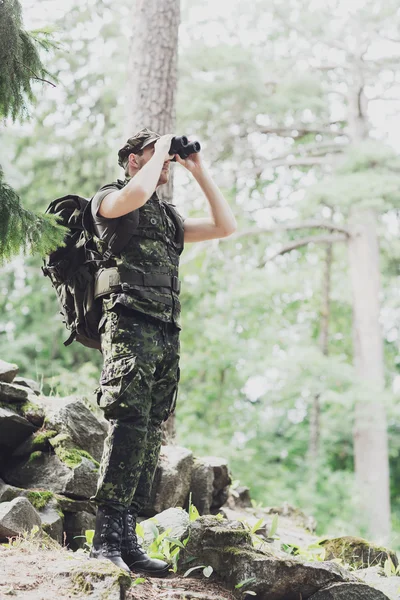 Soldat avec binoculaire et sac à dos en forêt — Photo