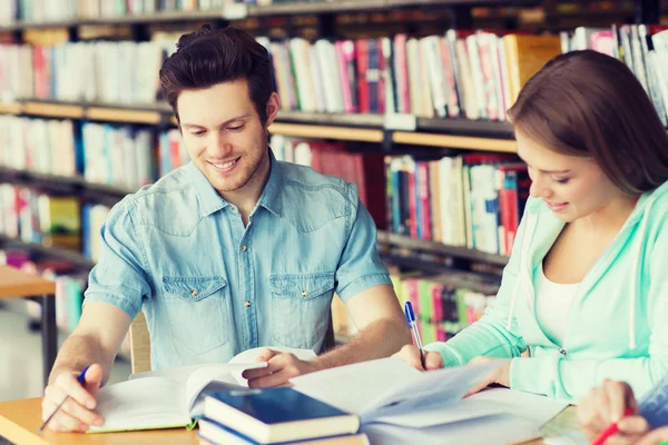 Studenci z książkami przygotowującymi do egzaminu w bibliotece — Zdjęcie stockowe