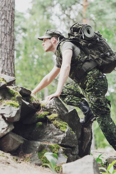 Jovem soldado com mochila na floresta — Fotografia de Stock