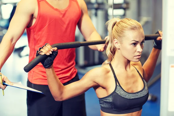 Mężczyzna i kobieta wyginanie mięśni na siłowni maszyna — Zdjęcie stockowe