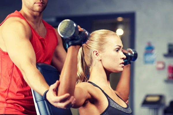 Uomo e donna con manubri in palestra — Foto Stock