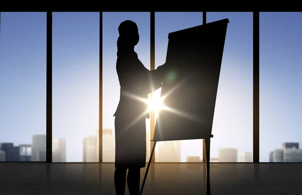 Silhouette of woman with flipboard over office — Stock Photo, Image