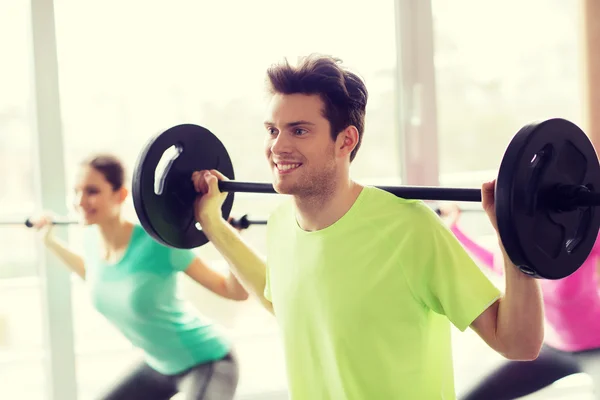 Group of people exercising with barbell in gym — Stock Photo, Image