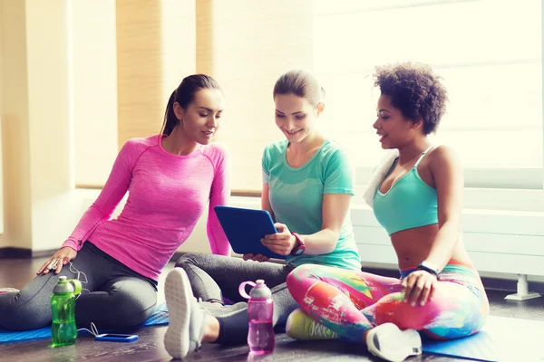 Grupo de mujeres felices con tableta PC en el gimnasio — Foto de Stock