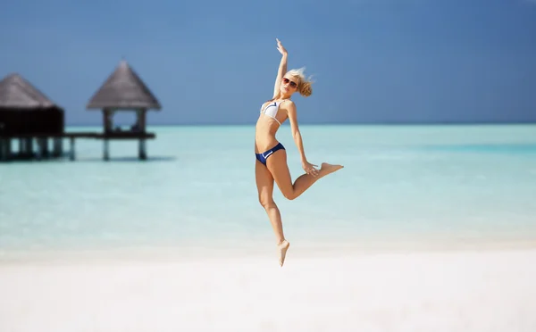 Feliz joven saltando sobre la playa exótica — Foto de Stock
