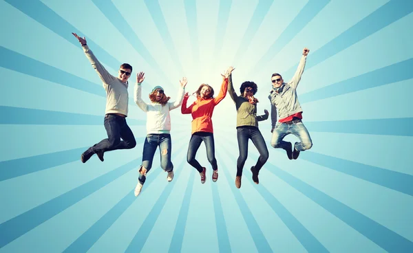 Ler vänner i solglasögon hoppar högt — Stockfoto