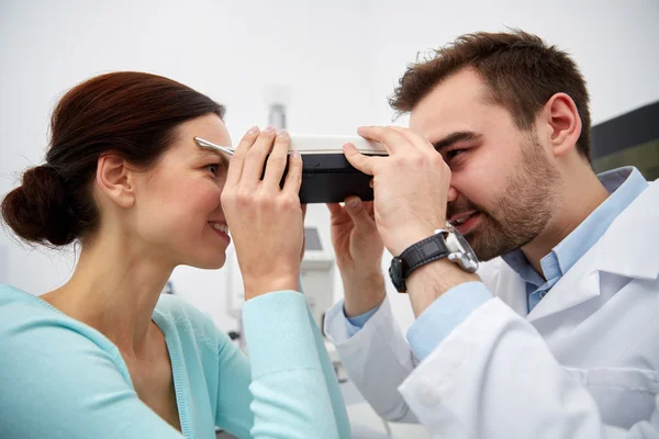 与 pupilometer 和在眼科门诊病人的配镜师 — 图库照片