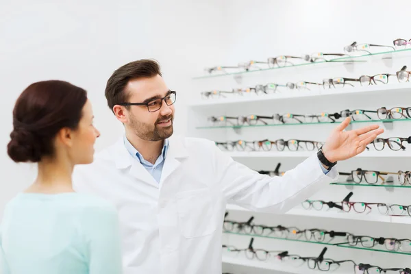 Kadın ve gözlük optik mağazasından gösterilen gözlükçü — Stok fotoğraf