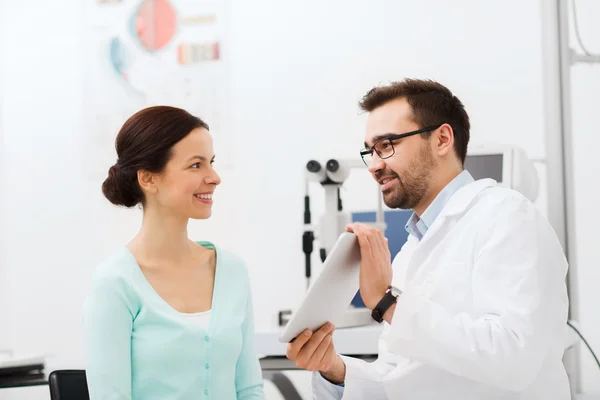 Optician with tablet pc and patient at eye clinic — Stock Photo, Image