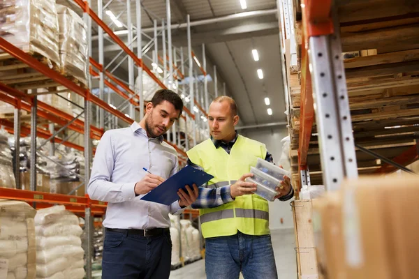 Arbeiter und Geschäftsleute mit Klemmbrett im Lager — Stockfoto