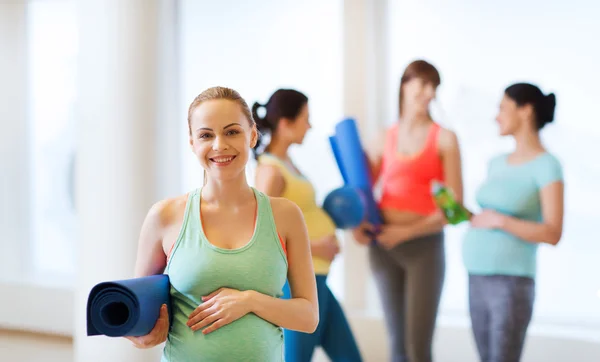 Happy pregnant woman with mat in gym — Stock Photo, Image