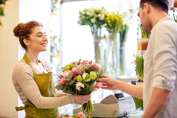 Sorridente florista mulher e homem na loja de flores — Fotografia de Stock