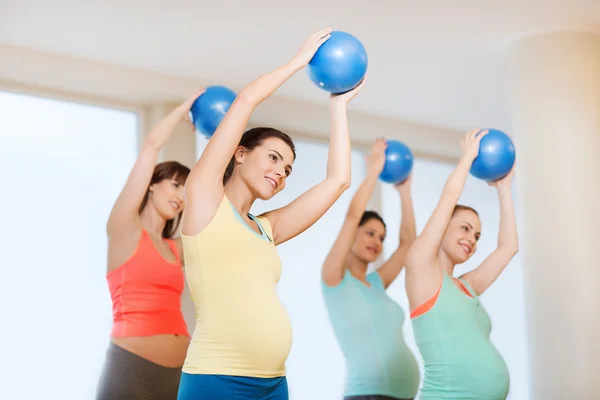 Glada gravida kvinnor träning med boll i gym — Stockfoto