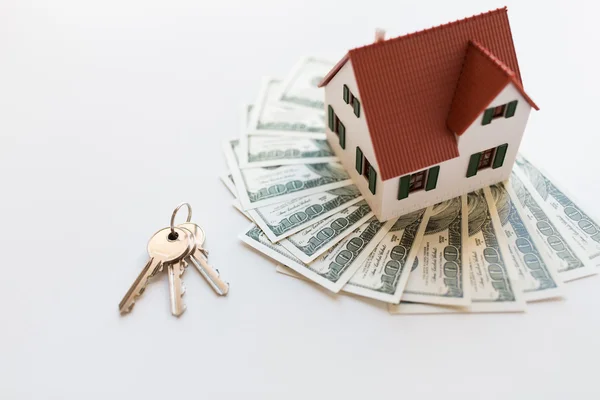 Vicino al modello di casa, soldi e chiavi di casa — Foto Stock