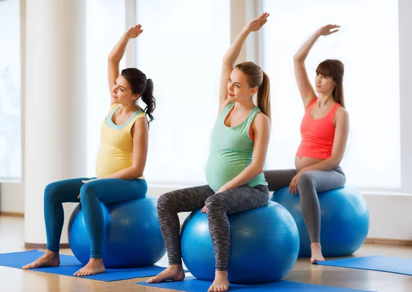 Mulheres grávidas felizes exercitando no fitball no ginásio — Fotografia de Stock