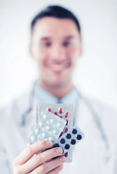 Médico masculino con paquetes de pastillas —  Fotos de Stock