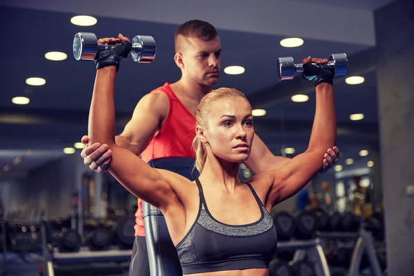 Чоловік і жінка з гантелями в спортзалі — стокове фото