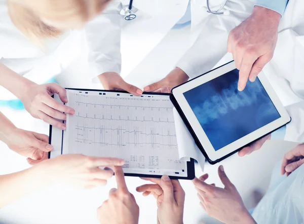 Grupp läkare titta på röntgen på TabletPC — Stockfoto