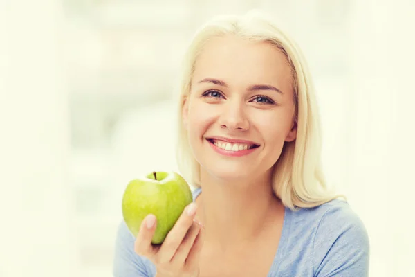 青リンゴを家で食べる幸せな女 — ストック写真