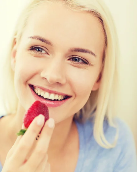 家でイチゴを食べる幸せな女 — ストック写真