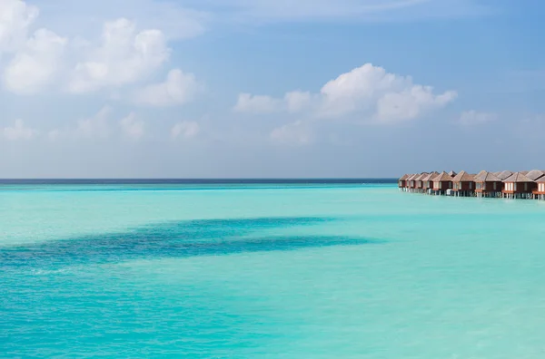 บังกะโลในน้ําทะเลบนชายหาดรีสอร์ทที่แปลกใหม่ — ภาพถ่ายสต็อก