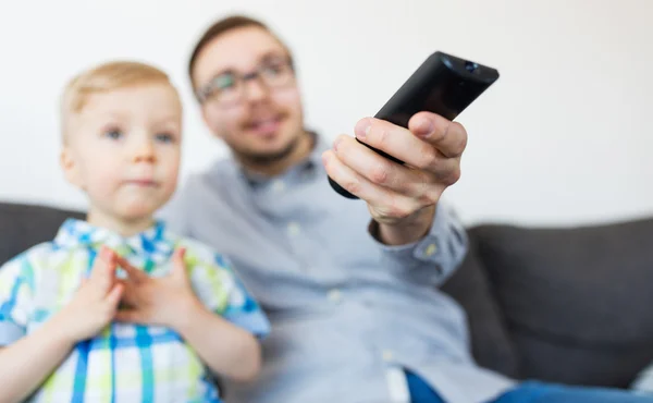 Vader en zoon met externe tv kijken thuis — Stockfoto