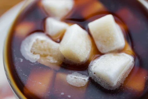 Primo piano di zucchero grumo in tazza di caffè o tè — Foto Stock