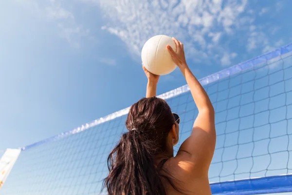 Mladá žena s míčem hrát volejbal na pláži — Stock fotografie