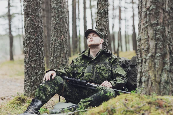 Soldat eller jägare med gun sover i skogen — Stockfoto