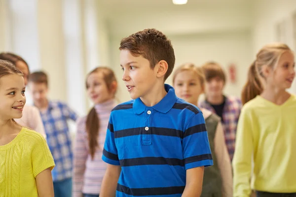 Grupp av leende skola barn gå i korridoren — Stockfoto