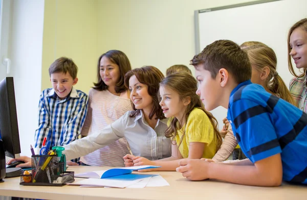 Groupe d'enfants avec professeur et ordinateur à l'école — Photo