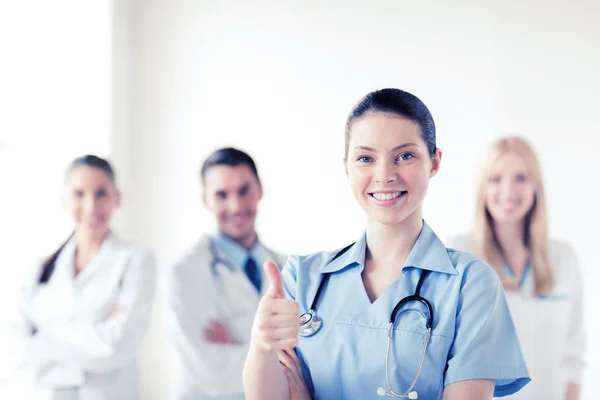 Médico com grupo de médicos mostrando polegares para cima — Fotografia de Stock