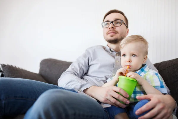 Baba ve oğul bardaktan içme ve evde — Stok fotoğraf