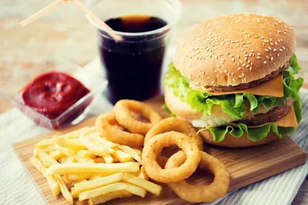 Close up of fast food snacks and drink on table — Stock Photo, Image