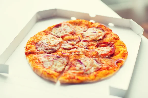 Close-up de pizza em caixa de papel na mesa — Fotografia de Stock