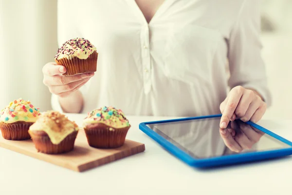 Close up of woman with cupcakes and tablet pc — Stock Photo, Image