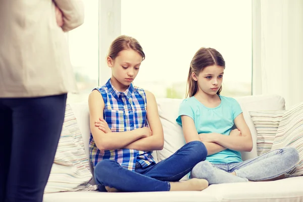 Upset guilty little girls sitting on sofa at home — Stock Photo, Image