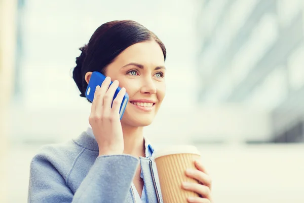 Lachende vrouw met koffie bellen op smartphone — Stockfoto