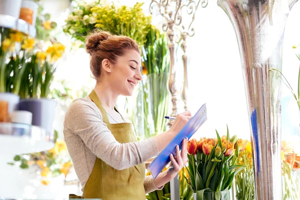 Florist woman with clipboard at flower shop — Stock Photo, Image